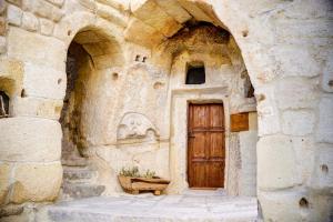 a building with a wooden door and a stone wall at Gibos Cave Hotel in Urgup