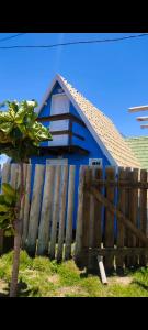 una casa azul con una valla de madera delante de ella en Chalé Barco da areia, en São Mateus