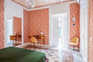 a bedroom with a bed and a desk and chairs at 124 Maqueda Apartments in Palermo