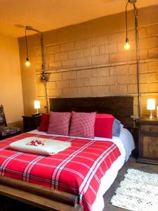 Schlafzimmer mit einem Bett mit roter und weißer Bettwäsche in der Unterkunft Mi Casa es tu Casa Inn in Chiquinquirá
