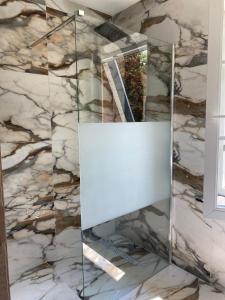 a mirror in a bathroom with a marble wall at Ardenne in Spa