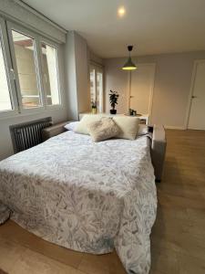 1 dormitorio con 1 cama grande con sábanas y almohadas blancas en Apartamento Cué en Gijón