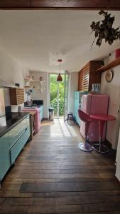 een keuken met roze en blauwe kasten en een rode kruk bij Chez Mary et Stef in Verdun-sur-Meuse