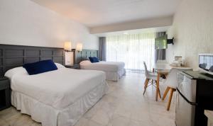 a large hotel room with two beds and a desk at State of the Art Condos en la mejor Playa de Cancun frente a PLAZA LA ISLA in Cancún