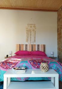 ナザレにあるCasa da Serraのベッドルーム1室(ピンクの枕とテーブル付きのベッド1台付)