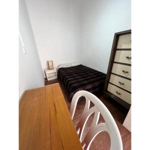 Habitación con cama y mesa de madera. en Hostal Mamaquilla, en Pasto
