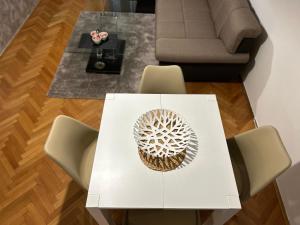 une table blanche et des chaises dans un salon dans l'établissement Apartments Ciki, à Podgorica