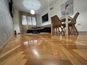 - un salon doté de parquet, d'une table et de chaises dans l'établissement Apartments Ciki, à Podgorica