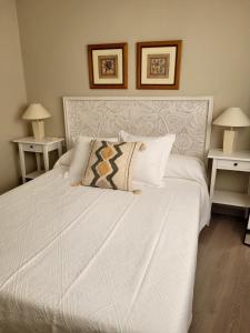 1 dormitorio con 1 cama blanca y 2 mesas en La Casa Alandí con garaje privado, en Sagunto