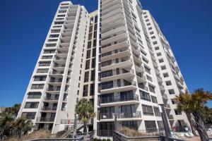 a tall white building with palm trees in front of it at Beachside II by Panhandle Getaways in Destin