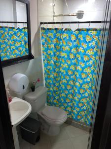 a bathroom with a toilet and a shower curtain at Apartamento Casa Betty Salento. in Salento +10 photos