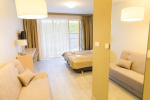 Habitación de hotel con cama y sofá en VacationClub - Ischgl Apartament 19, en Sienna