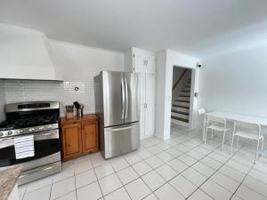 cocina con nevera de acero inoxidable y mesa en Letitia Heights !D Quiet and Stylish Private Bedroom with Shared Bathroom en Barrie