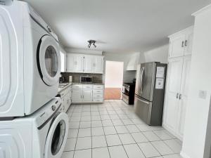 a kitchen with white cabinets and a washer and dryer at Letitia Heights !D Quiet and Stylish Private Bedroom with Shared Bathroom in Barrie