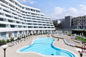 Un gran edificio con piscina en frente de un edificio. en דירת סטודיו מדהימה בסי סייד 50 מטר מהחוף - By Edomlux, en Eilat 8 fotos más