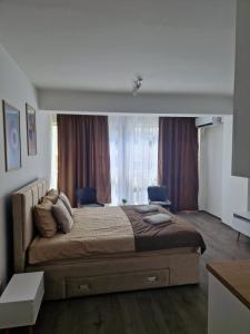 - une chambre avec un grand lit en face d'une fenêtre dans l'établissement Kamche apartment, à Skopje