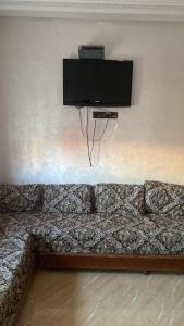 eine Wand mit einem TV an der Wand in der Unterkunft Lotissment oum kaltoum 2 in Martil