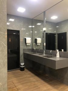 a bathroom with two sinks and a large mirror at FLAT CAVALINHO BRANCO in Águas de Lindóia