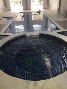 a large pool of water in a building at FLAT CAVALINHO BRANCO in Águas de Lindóia