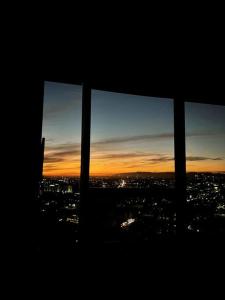 Blick auf eine Stadt von einem Fenster bei Sonnenuntergang in der Unterkunft Luxury Highrise Condo Downtown LA in Los Angeles