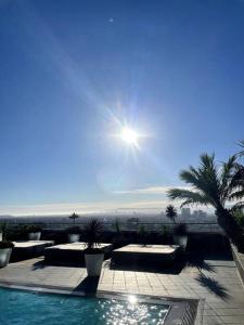 ein Pool mit Palmen und die Sonne am Himmel in der Unterkunft Luxury Highrise Condo Downtown LA in Los Angeles