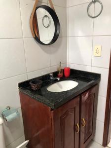 a bathroom with a sink and a mirror at Bangalô Doce lar in Gravatá