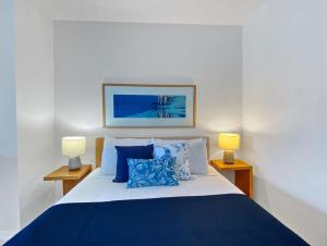 1 dormitorio con 1 cama azul y blanca y 2 lámparas en Blue on Blue Superior Studio Room 1321, en Nelly Bay