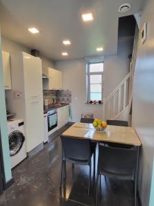 a kitchen with a table and chairs in a room at Le Domaine du Templier - Chapelain in Borre