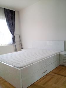 1 cama blanca grande en una habitación con ventana en Apartmani Aeredrom, en Sarajevo