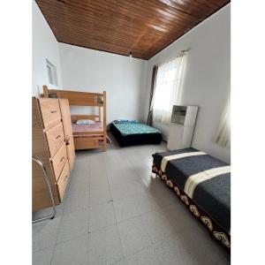 1 dormitorio con 2 camas, vestidor y ventana en Hostal Mamaquilla, en Pasto
