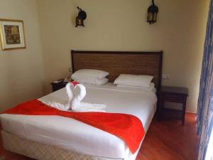 a bedroom with a bed with a red and white blanket at فندق و سبا بورتو مارينا in El Alamein