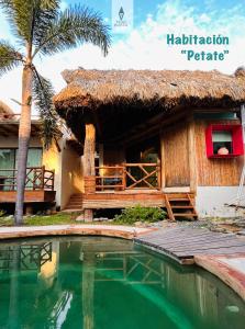 a resort with a swimming pool and a hut at A&V Hotel Boutique in Acapulco