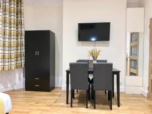 a dining room with a black table and chairs at Brighton Studio Flats in Brighton & Hove