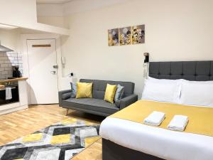 a bedroom with a large bed and a couch at Brighton Studio Flats in Brighton & Hove