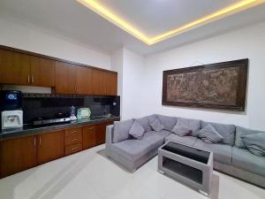 ein Wohnzimmer mit einem Sofa und einer Küche in der Unterkunft Maha Private Villa in Ubud
