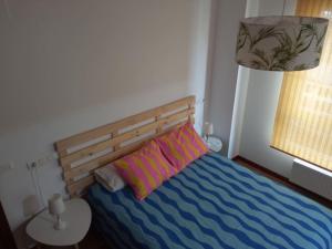 a bedroom with a bed with a wooden head board at Bonito Apartamento en Aviles in Avilés