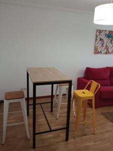 a table and chairs in a living room with a couch at Bonito Apartamento en Aviles in Avilés