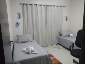 a bedroom with two beds and a stuffed animal on the bed at Casa completa a 12 minutos de Betel in Tatuí