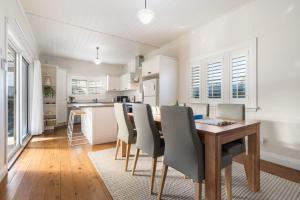 a kitchen and dining room with a wooden table and chairs at Sampson Cottage - Historic Charm in Orange