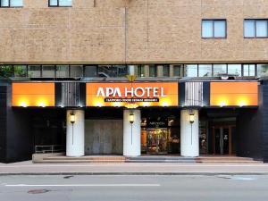 a building with an ap&aacute;n hotel on a city street at APA Hotel Sapporo Odori Ekimae Minami in Sapporo