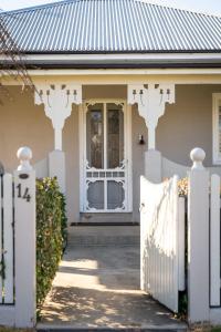 uma cerca branca em frente a uma casa com uma porta em Sampson Cottage - Historic Charm em Orange