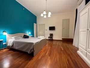 ein Schlafzimmer mit einem Bett und einer blauen Wand in der Unterkunft Borgo Antico B&b in Foggia