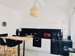 - une cuisine avec une table, une cuisinière et un évier dans l'établissement Le Repère de B&C, à Cenon 7 autres photos