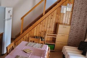 Zimmer mit einem Tisch und einer Treppe mit einem Kühlschrank in der Unterkunft Seaside holiday house Unesic - Unije, Losinj - 8045 in Unije
