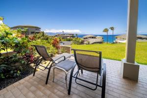2 sedie sedute su un patio con vista sull'oceano di Kapalua Villas Maui a Lahaina