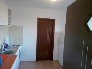a kitchen with a brown door and a refrigerator at Vila Antonia in Eforie Nord