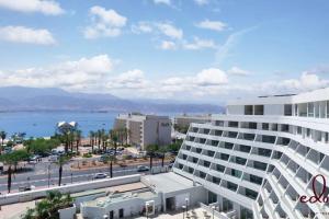 - une vue sur un grand bâtiment blanc et une ville dans l'établissement דירת גן במתחם סי סייד 100 מטר מהים - By Edom, à Eilat