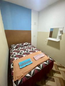Blue House - cerca del consulado americano في غواياكيل: غرفة بها لوحة مفاتيح للكمبيوتر على سرير