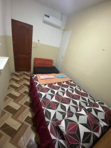 um pequeno quarto com uma cama num quarto em Blue House - cerca del consulado americano em Guayaquil