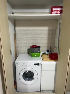 una lavatrice e asciugatrice in una piccola cucina di Casa Vacanze Bedda do Ziu a Mascali